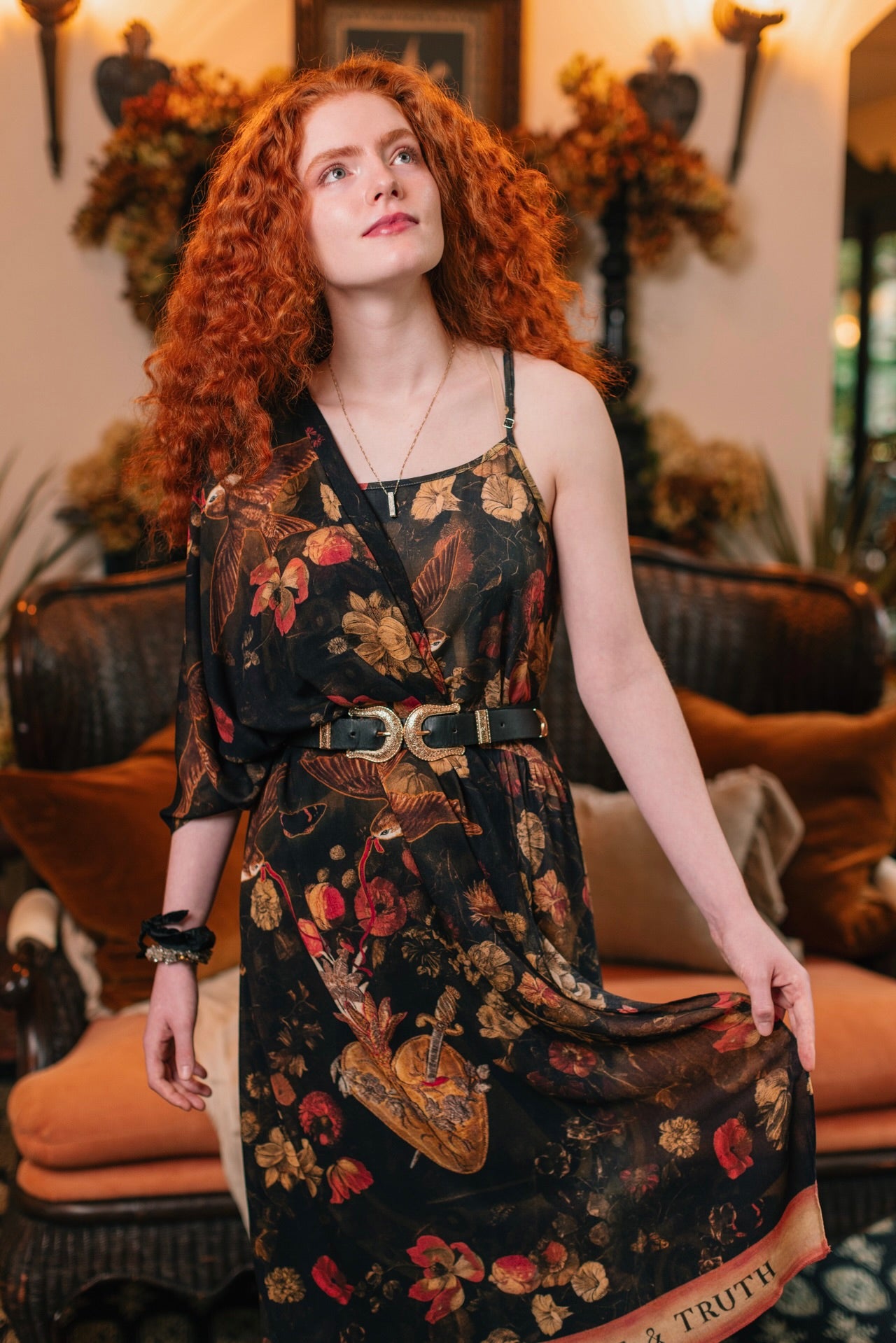 Model wearing a bamboo-viscose scarf featuring a collage of antique artwork that celebrates the bonds in our lives that endure — love, truth, and loyal friends!