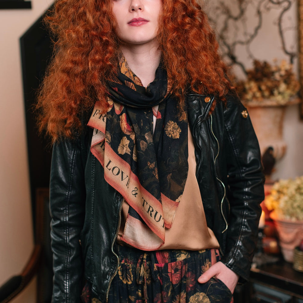 
                  
                    Model wearing a bamboo-viscose scarf featuring a collage of antique artwork that celebrates the bonds in our lives that endure — love, truth, and loyal friends!
                  
                