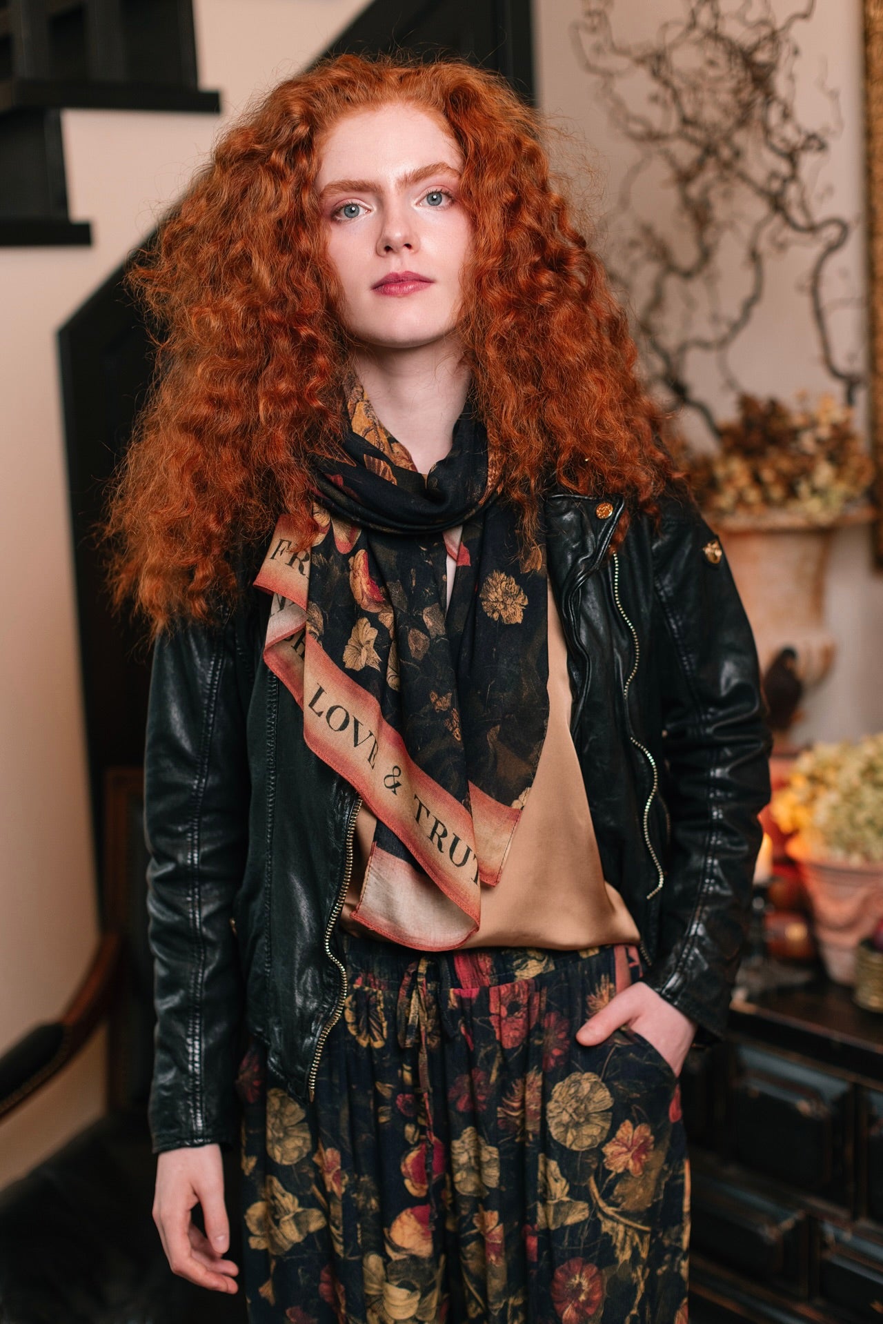 Model wearing a bamboo-viscose scarf featuring a collage of antique artwork that celebrates the bonds in our lives that endure — love, truth, and loyal friends!