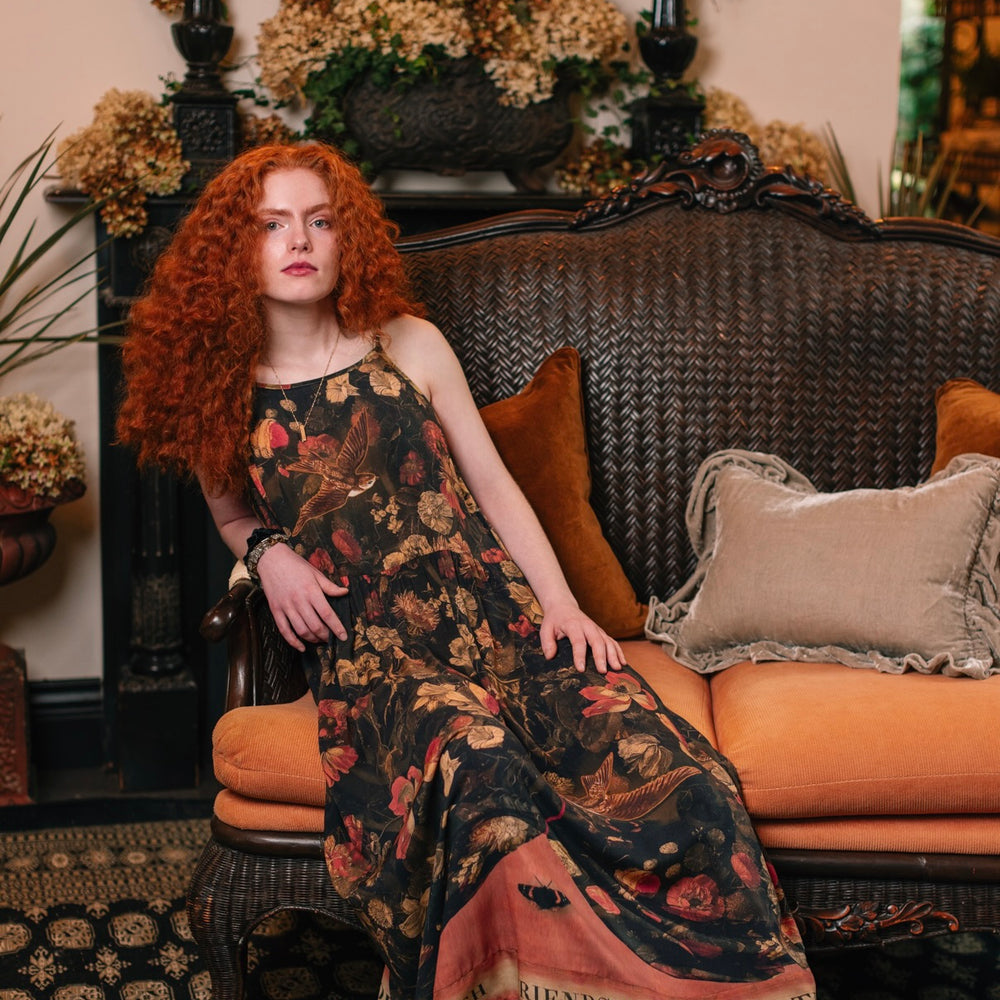 Model wearing a maxi-length bamboo-viscose slip dress featuring a collage of antique artwork with romance, loyalty, and old-world beauty - Market of Stars