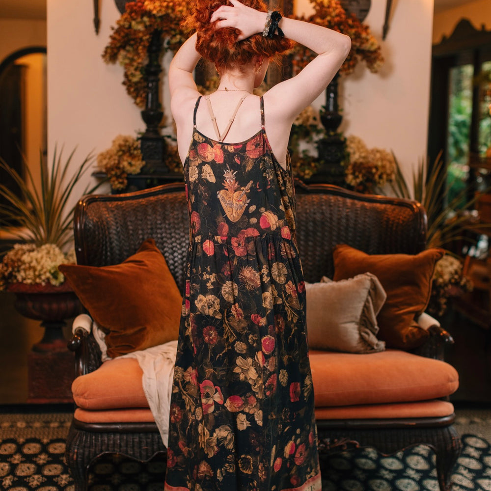
                  
                    Model wearing a maxi-length bamboo-viscose slip dress featuring a collage of antique artwork with romance, loyalty, and old-world beauty - Market of Stars
                  
                