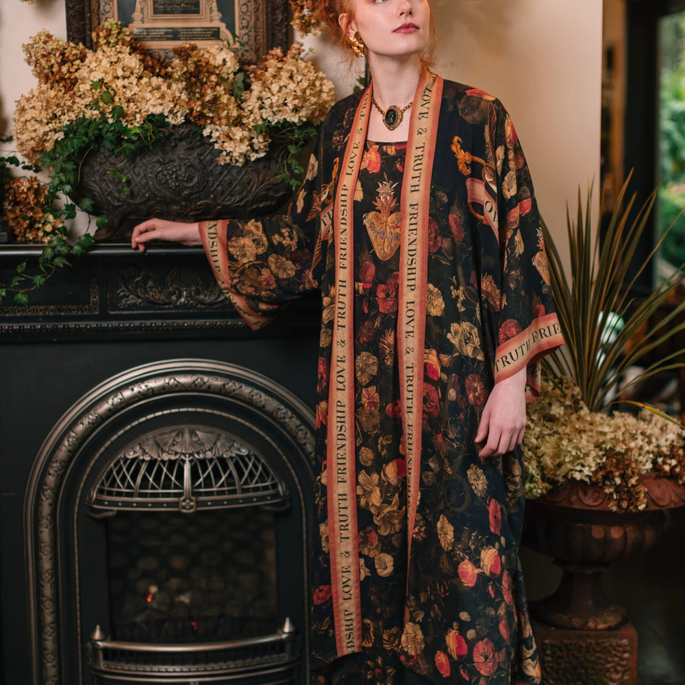 
                  
                    Model wearing a maxi-length bamboo-viscose slip dress featuring a collage of antique artwork with romance, loyalty, and old-world beauty - Market of Stars
                  
                