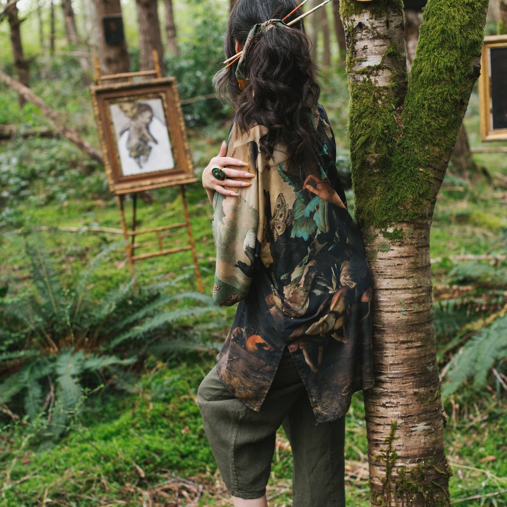 
                  
                    Model wearing the Heartwork Cropped Kimono featuring Artemisia Gentileschi’s self-portrait with lush forest, birds, and butterflies – Market of Stars.
                  
                