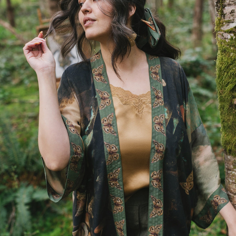 
                  
                    Model wearing the Heartwork Cropped Kimono featuring Artemisia Gentileschi’s self-portrait with lush forest, birds, and butterflies – Market of Stars.
                  
                