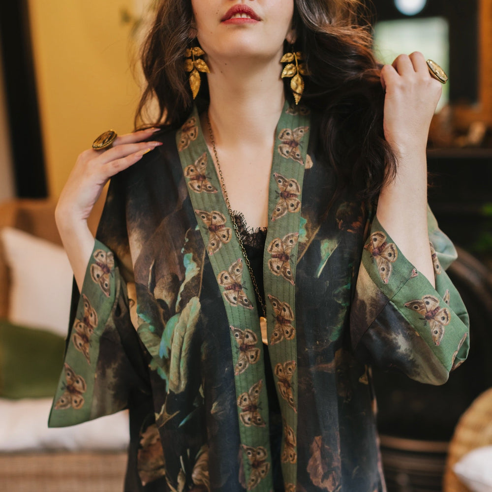 
                  
                    Model wearing the Heartwork Cropped Kimono featuring Artemisia Gentileschi’s self-portrait with lush forest, birds, and butterflies – Market of Stars.
                  
                