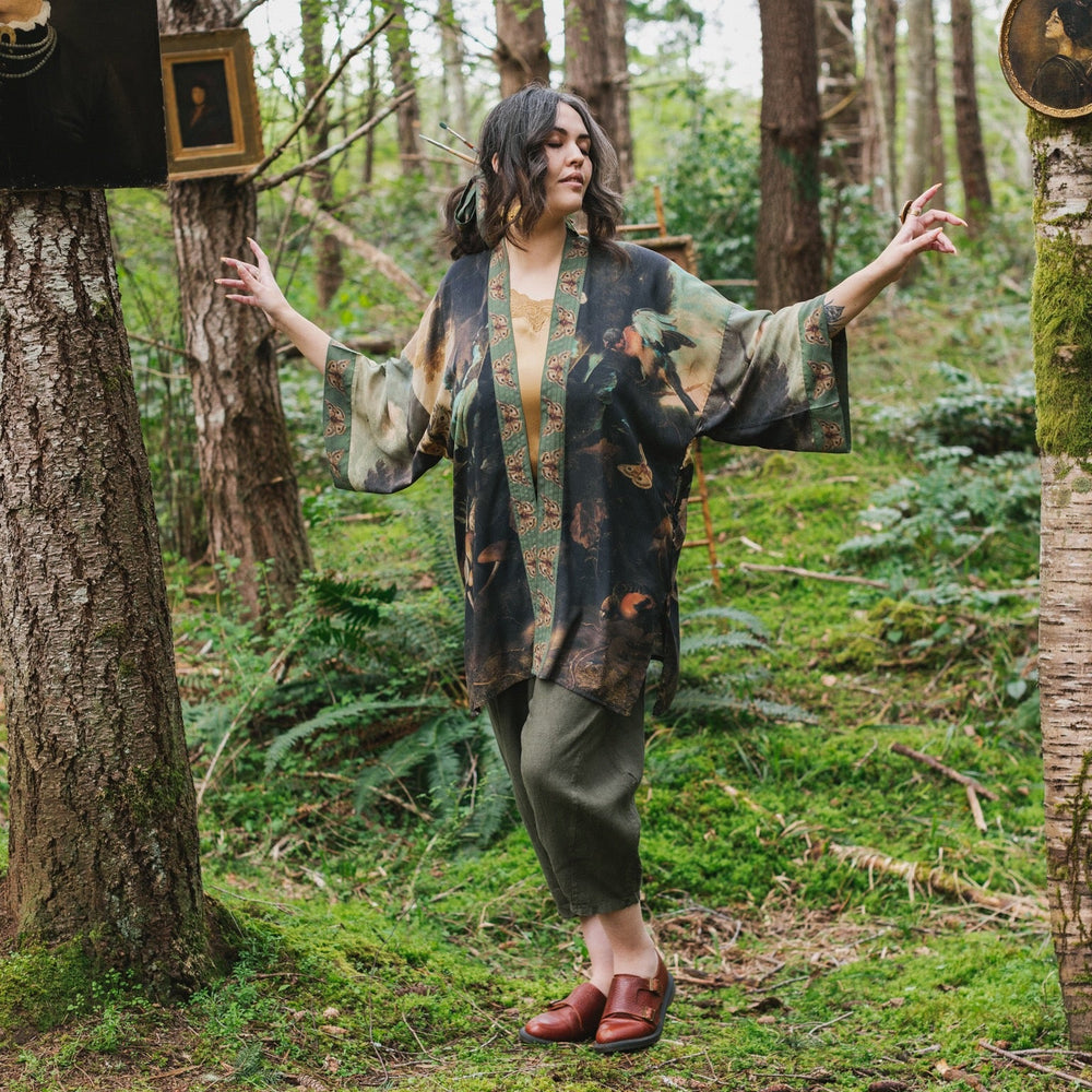 
                  
                    Model wearing the Heartwork Cropped Kimono featuring Artemisia Gentileschi’s self-portrait with lush forest, birds, and butterflies – Market of Stars.
                  
                