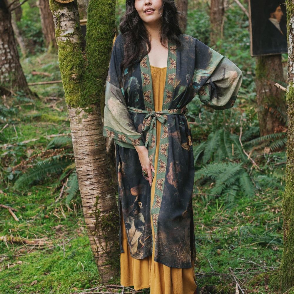 
                  
                    Model wearing the Heartwork Opera Duster featuring Artemisia Gentileschi’s self-portrait surrounded by forest, birds, and butterflies – Market of Stars.
                  
                