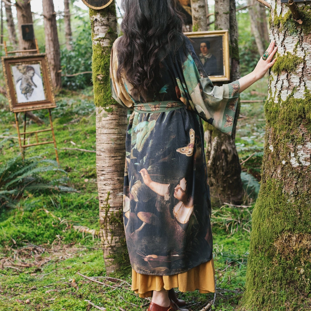 
                  
                    Model wearing the Heartwork Opera Duster featuring Artemisia Gentileschi’s self-portrait surrounded by forest, birds, and butterflies – Market of Stars.
                  
                