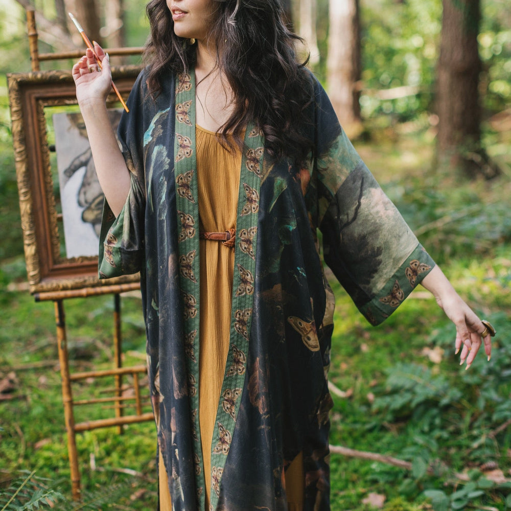 
                  
                    Model wearing the Heartwork Opera Duster featuring Artemisia Gentileschi’s self-portrait surrounded by forest, birds, and butterflies – Market of Stars.
                  
                