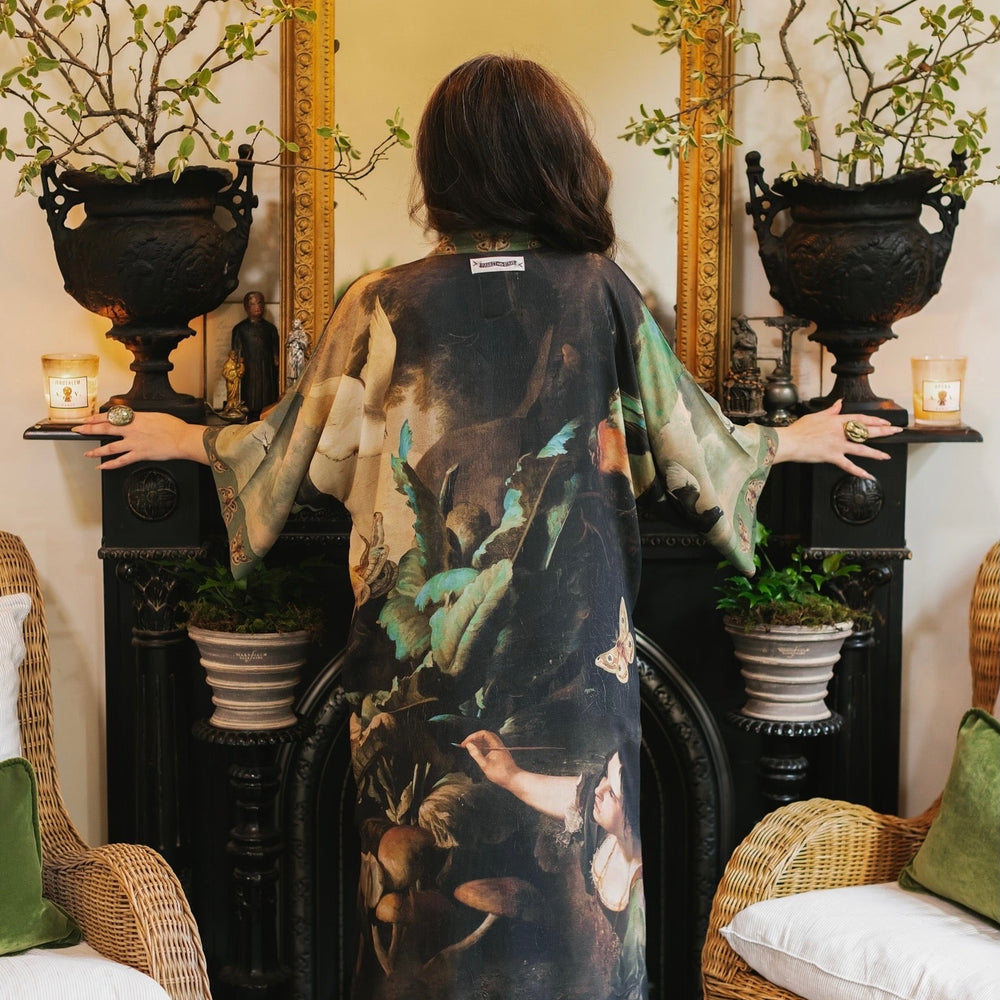 
                  
                    Model wearing the Heartwork Opera Duster featuring Artemisia Gentileschi’s self-portrait surrounded by forest, birds, and butterflies – Market of Stars.
                  
                