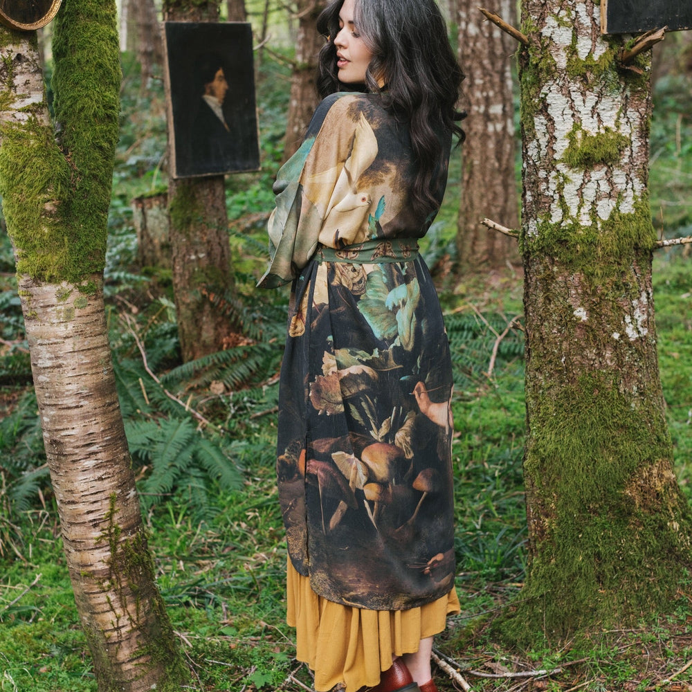 
                  
                    Model wearing the Heartwork Opera Duster featuring Artemisia Gentileschi’s self-portrait surrounded by forest, birds, and butterflies – Market of Stars.
                  
                