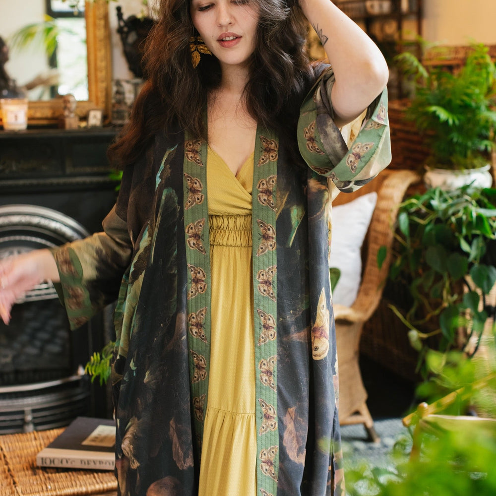 
                  
                    Model wearing the Heartwork Opera Duster featuring Artemisia Gentileschi’s self-portrait surrounded by forest, birds, and butterflies – Market of Stars.
                  
                