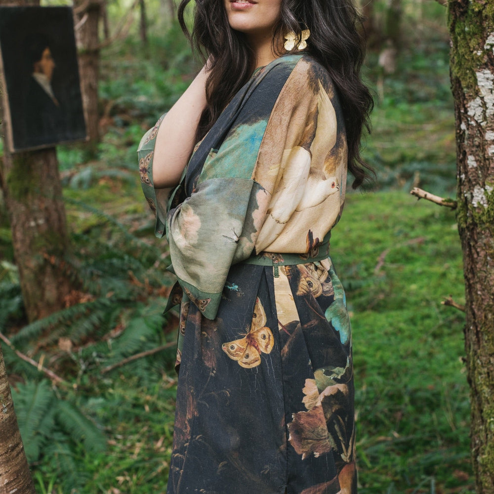 
                  
                    Model wearing the Heartwork Opera Duster featuring Artemisia Gentileschi’s self-portrait surrounded by forest, birds, and butterflies – Market of Stars.
                  
                
