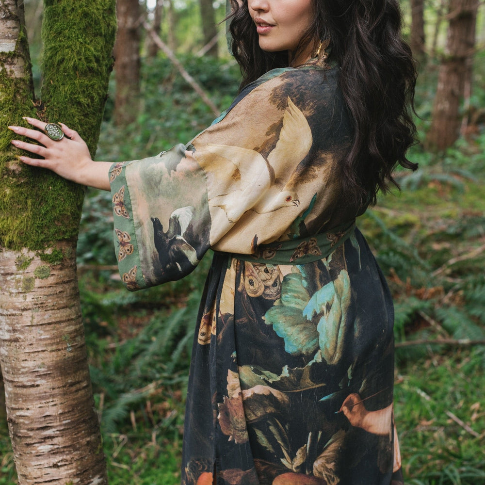 
                  
                    Model wearing the Heartwork Opera Duster featuring Artemisia Gentileschi’s self-portrait surrounded by forest, birds, and butterflies – Market of Stars.
                  
                