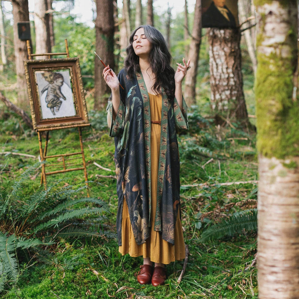 
                  
                    Model wearing the Heartwork Opera Duster featuring Artemisia Gentileschi’s self-portrait surrounded by forest, birds, and butterflies – Market of Stars.
                  
                