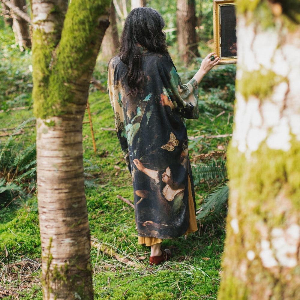 
                  
                    Model wearing the Heartwork Opera Duster featuring Artemisia Gentileschi’s self-portrait surrounded by forest, birds, and butterflies – Market of Stars.
                  
                