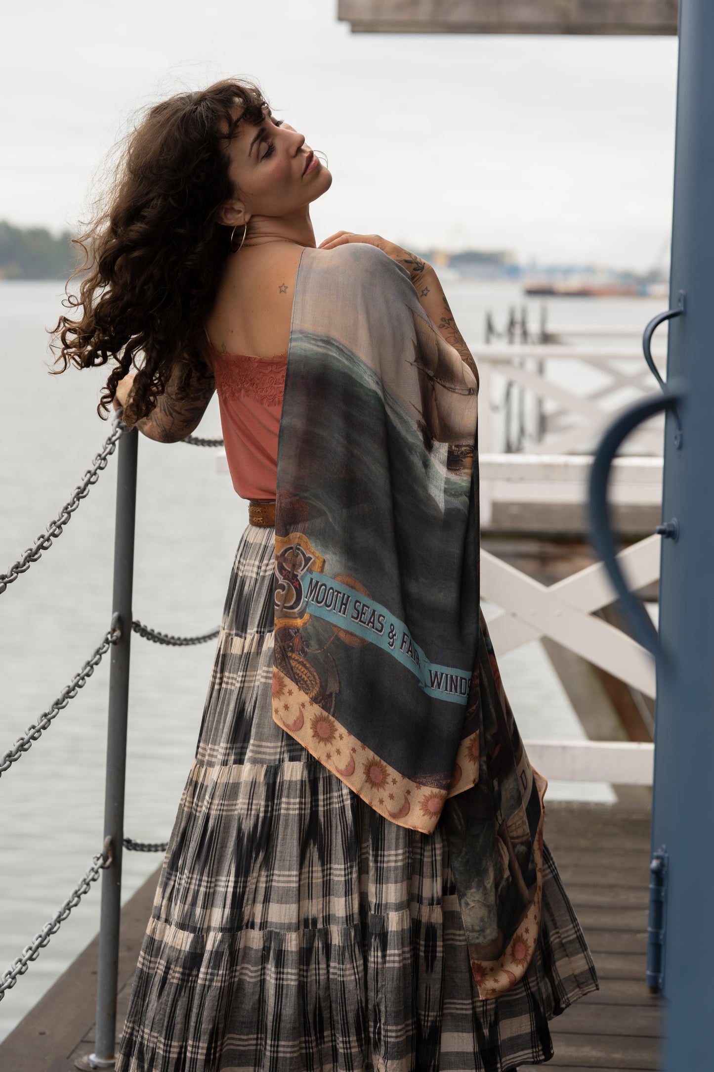 Model wearing the Hold Fast bamboo viscose scarf featuring a Victorian woman bravely rowing through a storm, seagulls, and rainbow horizon – Market of Stars.