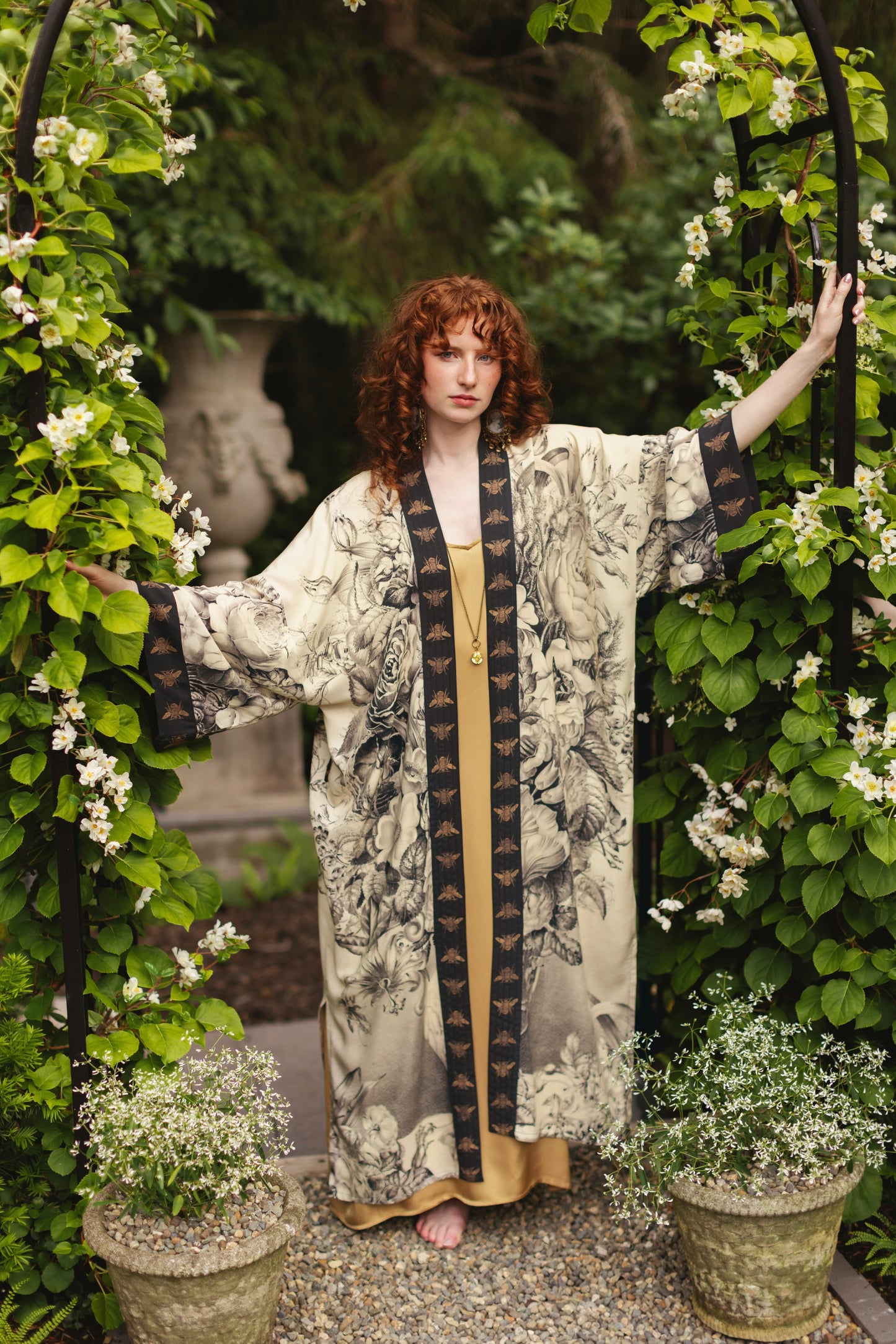 Model wearing a full-length opera duster featuring black-and-ivory floral lithographs from the 1900's - Market of Stars