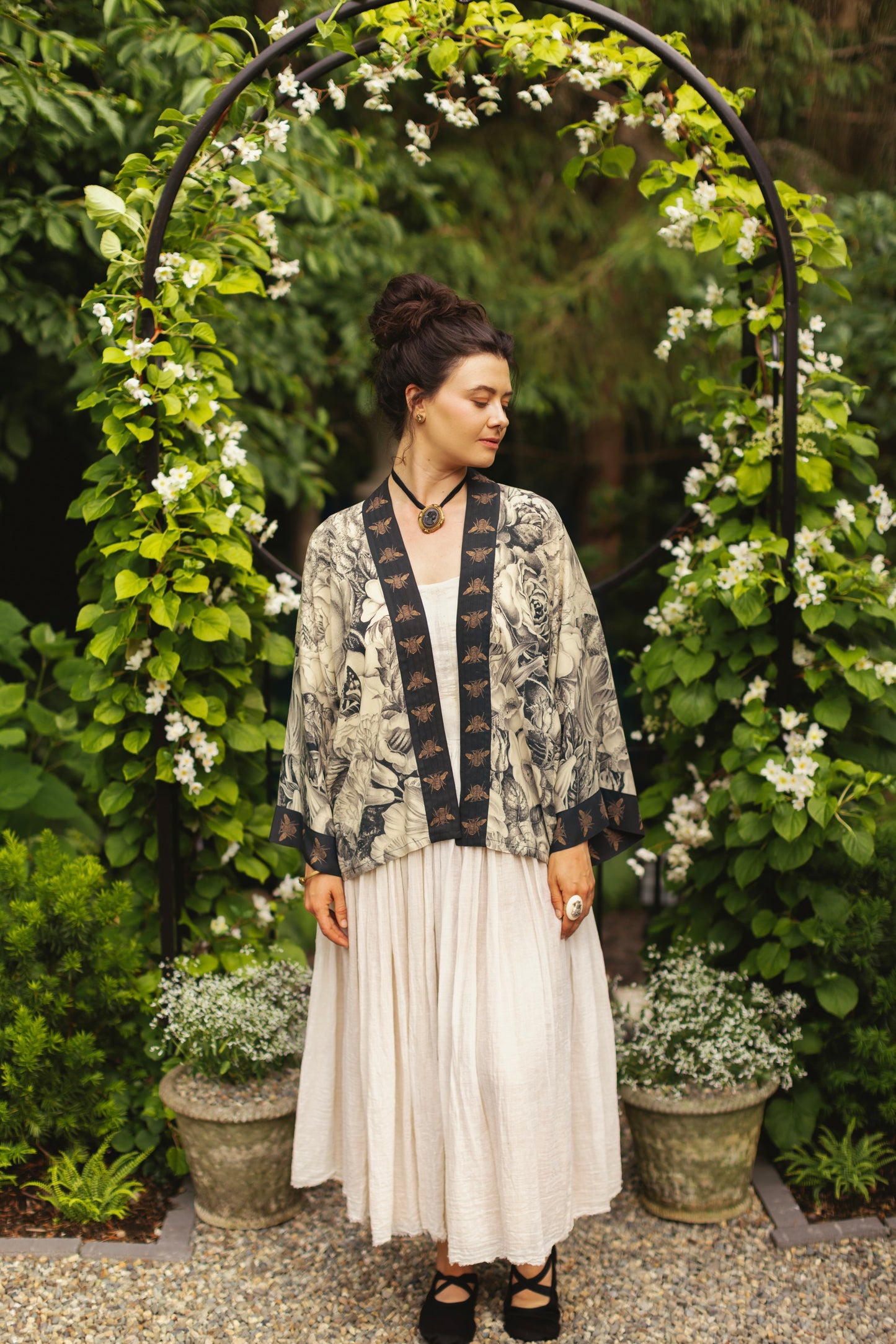 Model wearing a cropped length duster featuring black-and-ivory floral lithographs from the 1900's - Market of Stars