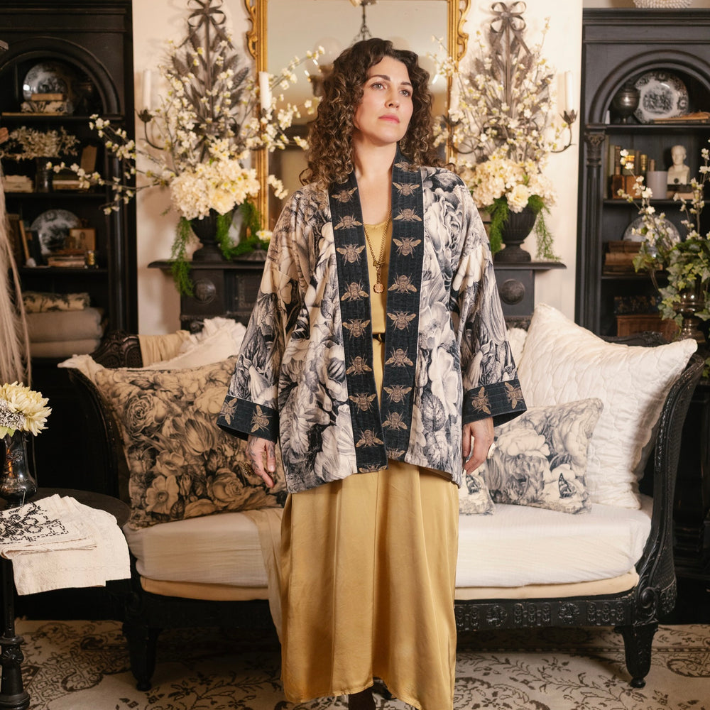 
                  
                    Model wearing a soft cotton velvet duster ft. 1900's floral lithographs. A garden dreamt up in ink - Market of Stars
                  
                