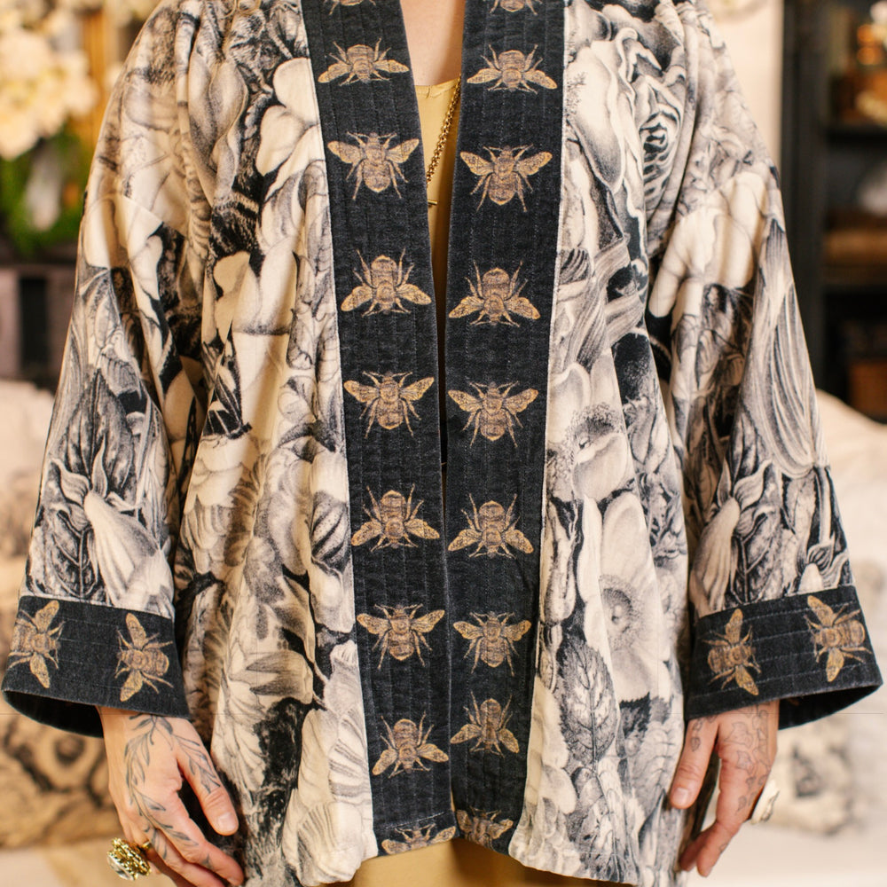 
                  
                    Model wearing a soft cotton velvet duster ft. 1900's floral lithographs. A garden dreamt up in ink - Market of Stars
                  
                