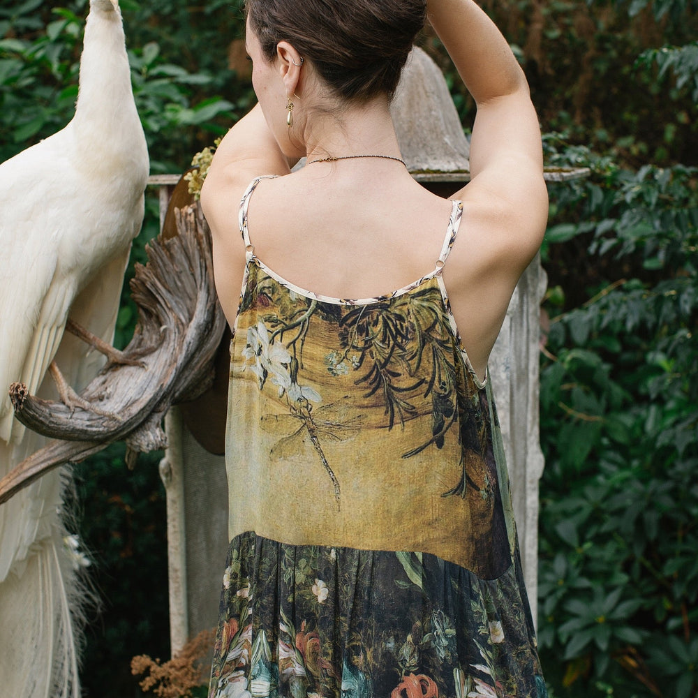 
                  
                    Model wearing the I Dream in Flowers Bohéme Slip Dress with vintage-inspired floral artwork and Victorian bumblebee details, perfect for layering or lounging – Market of Stars.
                  
                