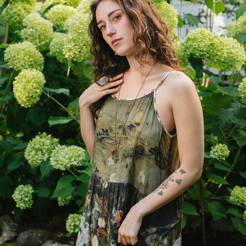 
                  
                    Model wearing the I Dream in Flowers Bohéme Slip Dress with vintage-inspired floral artwork and Victorian bumblebee details, perfect for layering or lounging – Market of Stars.
                  
                