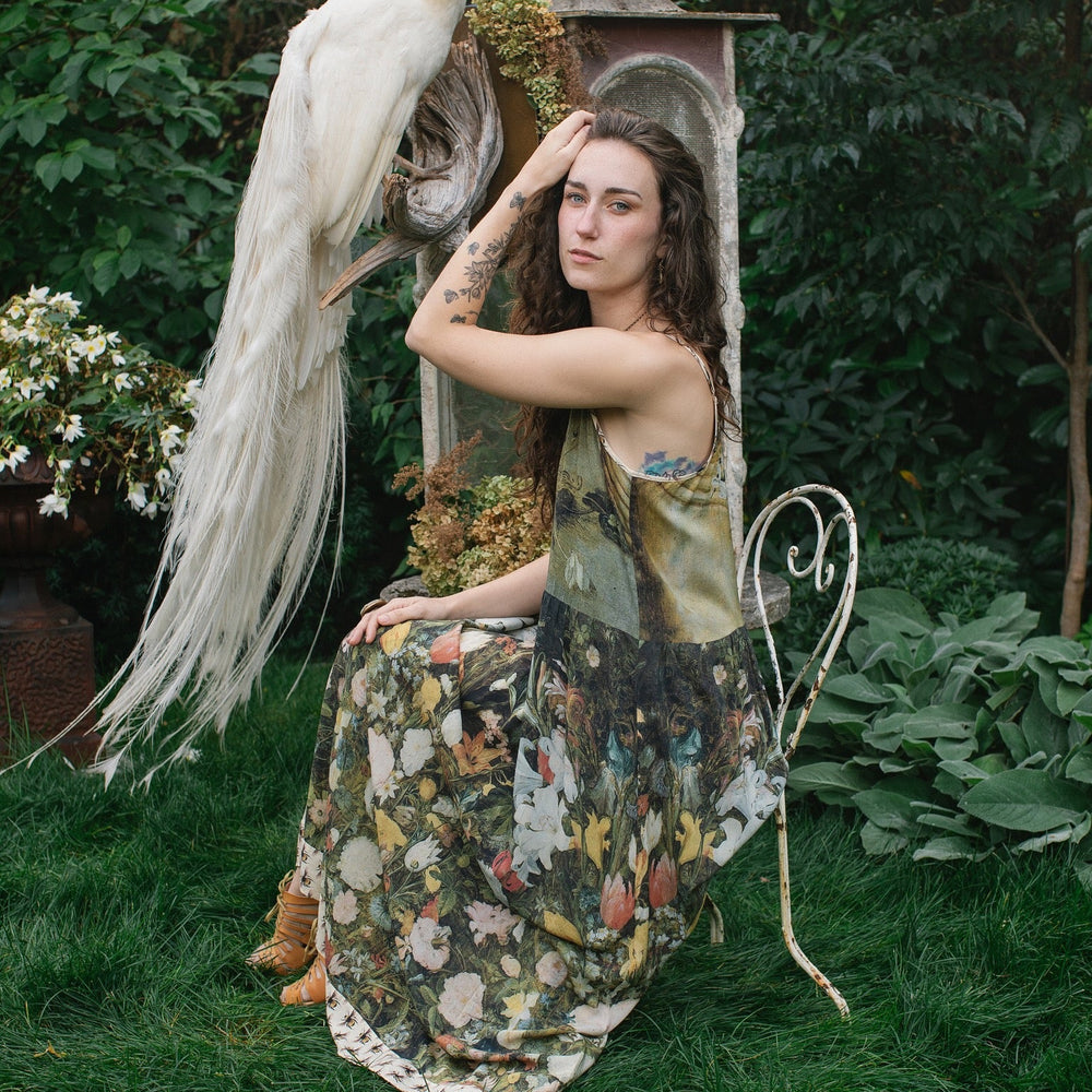 
                  
                    Model wearing the I Dream in Flowers Bohéme Slip Dress with vintage-inspired floral artwork and Victorian bumblebee details, perfect for layering or lounging – Market of Stars.
                  
                