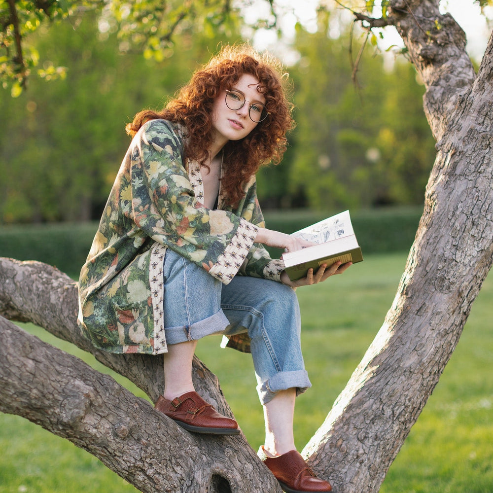
                  
                    Model wearing the I Dream in Flowers Cottage Cardigan featuring painterly floral artwork and Victorian bumblebee trim, perfect for cozy layering – Market of Stars
                  
                