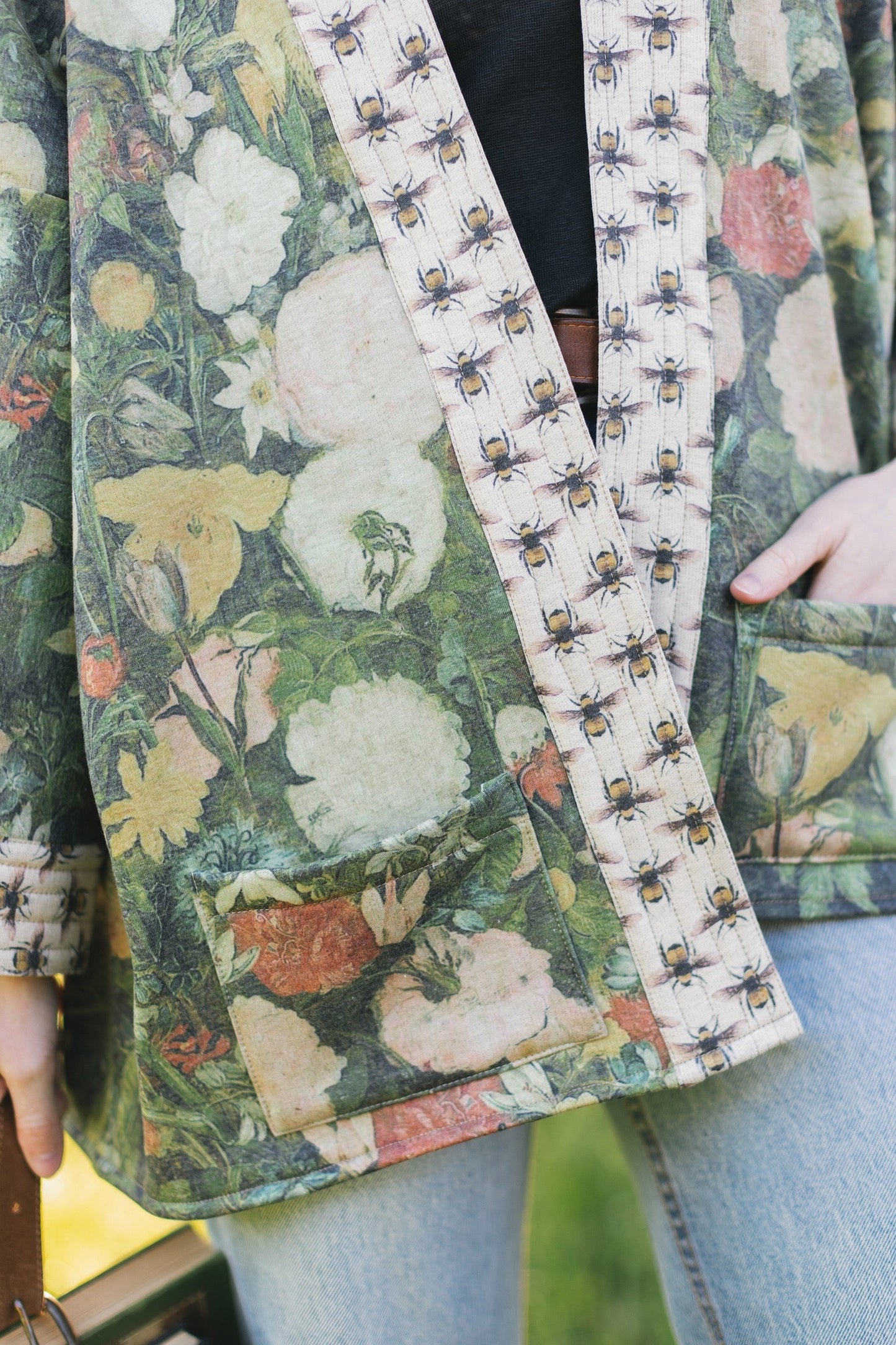 Model wearing the I Dream in Flowers Cottage Cardigan featuring painterly floral artwork and Victorian bumblebee trim, perfect for cozy layering – Market of Stars