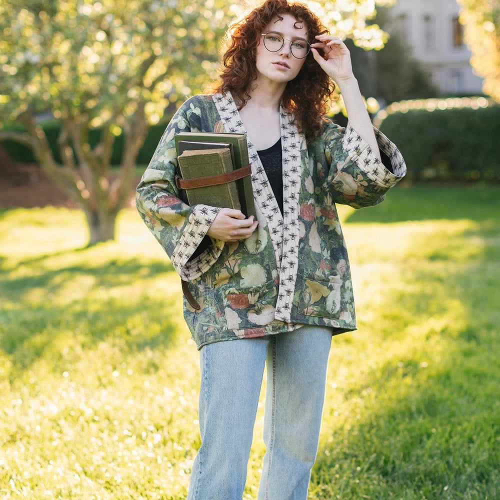 
                  
                    Model wearing the I Dream in Flowers Cottage Cardigan featuring painterly floral artwork and Victorian bumblebee trim, perfect for cozy layering – Market of Stars
                  
                