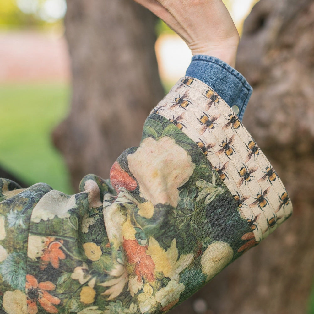 
                  
                    Model wearing the I Dream in Flowers Cottage Cardigan featuring painterly floral artwork and Victorian bumblebee trim, perfect for cozy layering – Market of Stars
                  
                