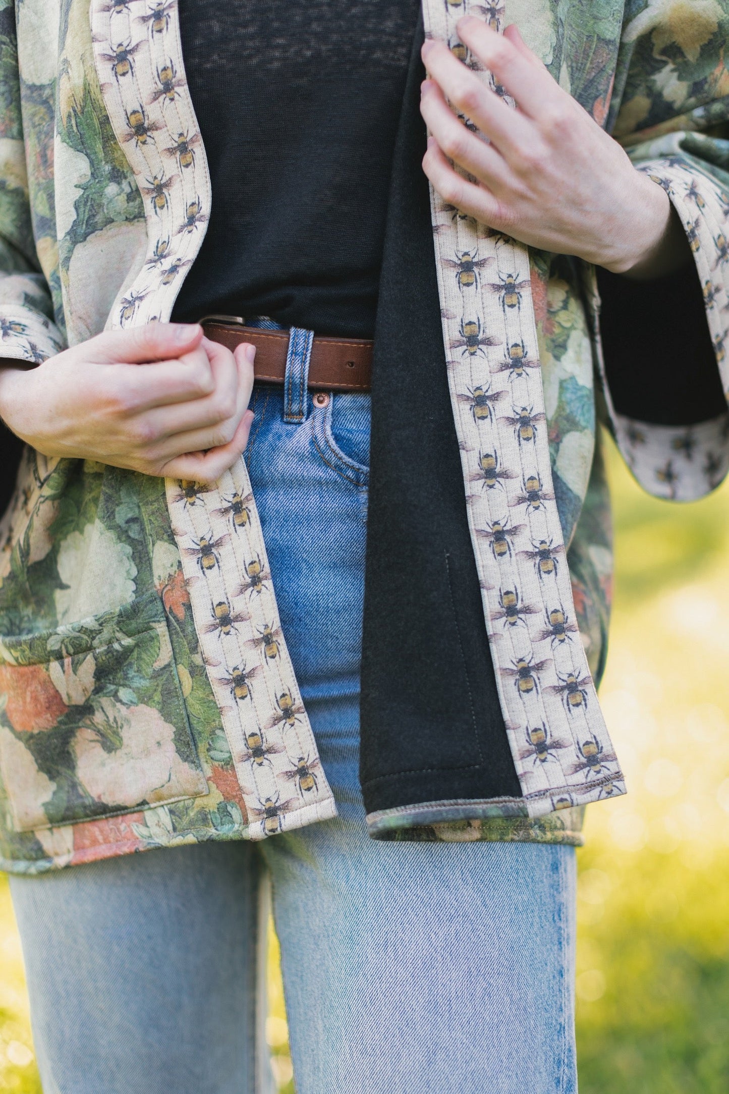 Model wearing the I Dream in Flowers Cottage Cardigan featuring painterly floral artwork and Victorian bumblebee trim, perfect for cozy layering – Market of Stars