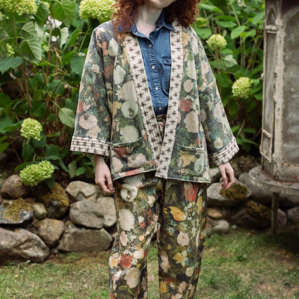 
                  
                    Model wearing the I Dream in Flowers Artist Pants featuring romantic floral artwork by Jan Brueghel and Victorian bumblebee trim, styled for everyday ease – Market of Stars
                  
                