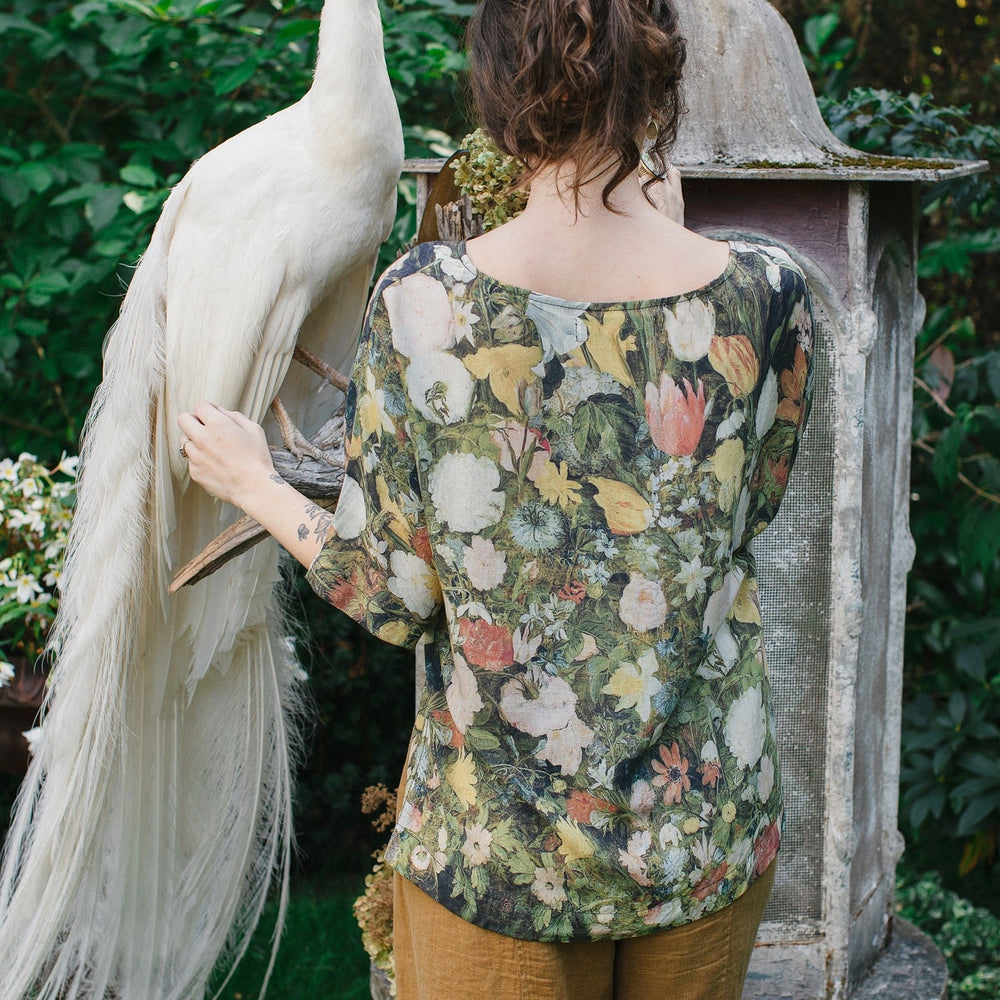 Model wearing the I Dream in Flowers Luxe Tee featuring painterly florals by Jan Brueghel and hidden bumblebee trim – Market of Stars.