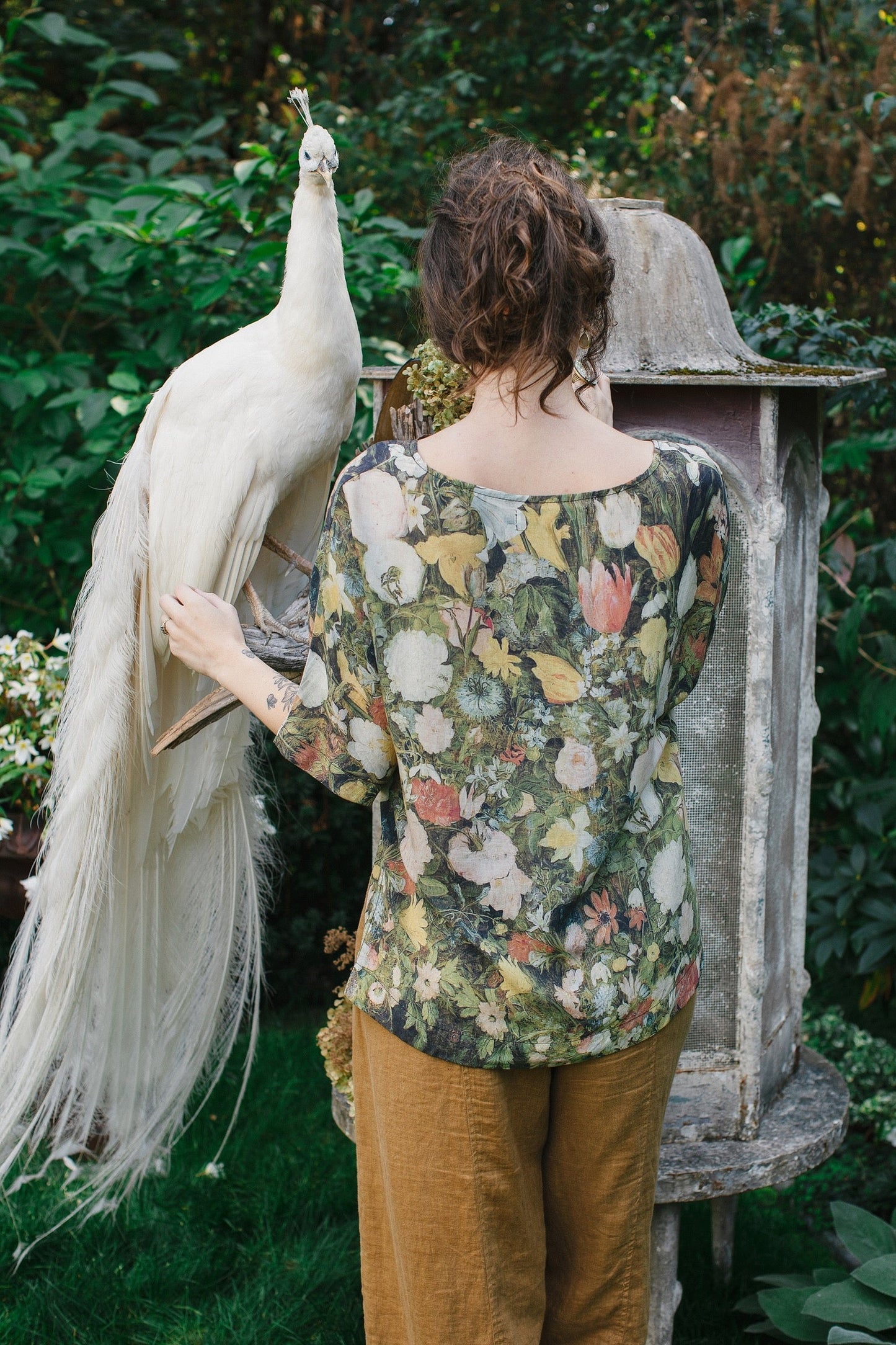 Model wearing the I Dream in Flowers Luxe Tee featuring painterly florals by Jan Brueghel and hidden bumblebee trim – Market of Stars.
