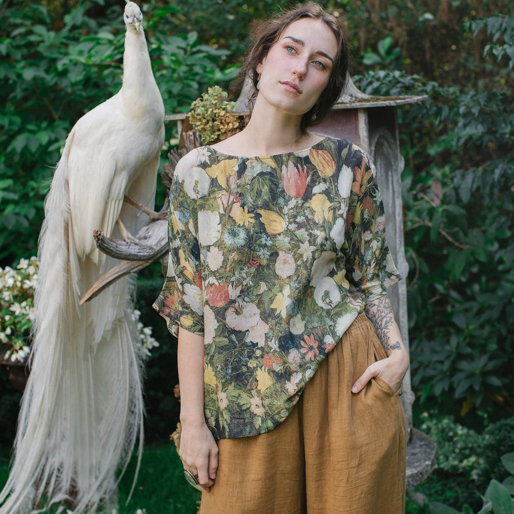 
                  
                    Model wearing the I Dream in Flowers Luxe Tee featuring painterly florals by Jan Brueghel and hidden bumblebee trim – Market of Stars.
                  
                