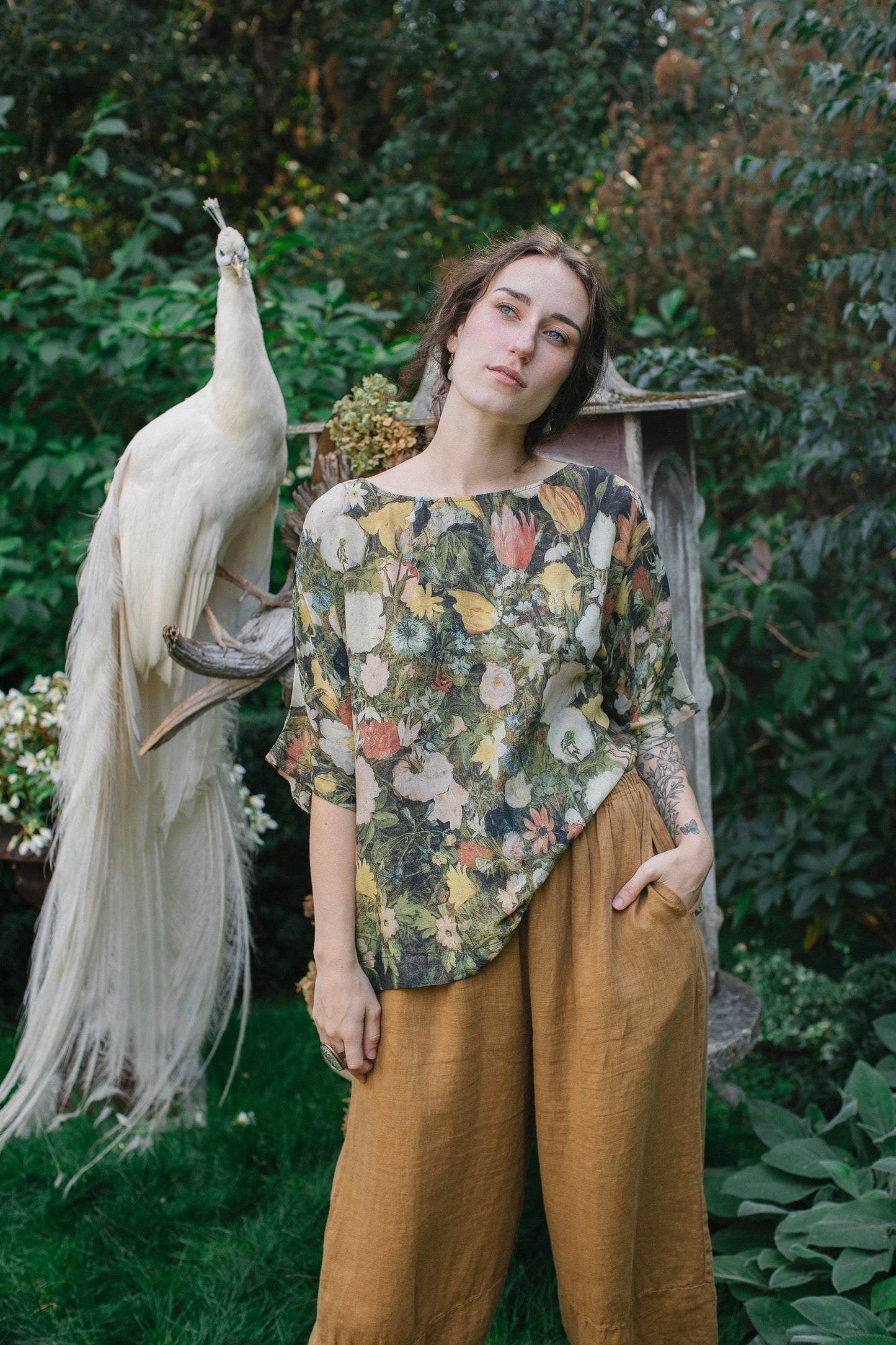 Model wearing the I Dream in Flowers Luxe Tee featuring painterly florals by Jan Brueghel and hidden bumblebee trim – Market of Stars.