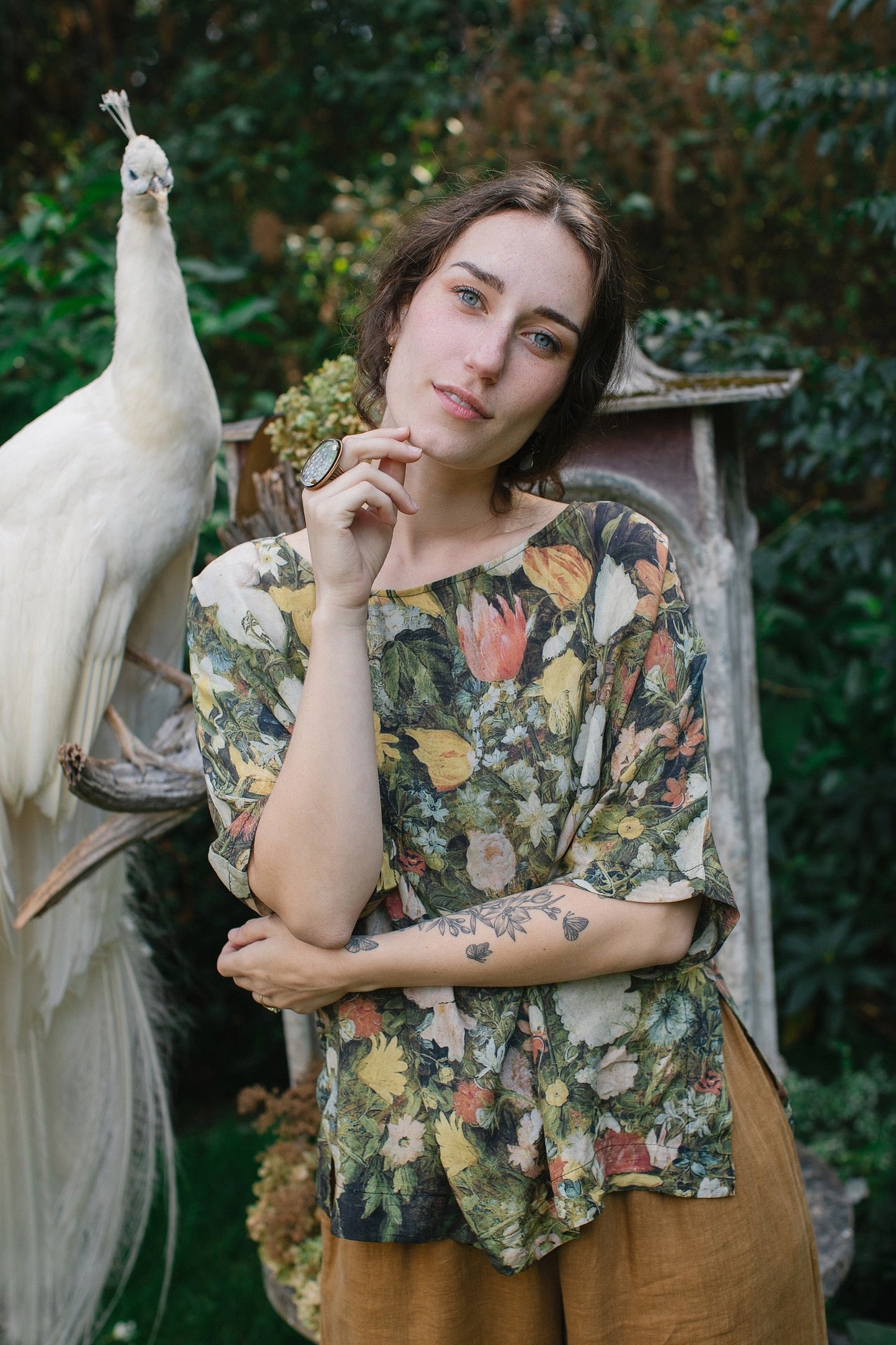 Model wearing the I Dream in Flowers Luxe Tee featuring painterly florals by Jan Brueghel and hidden bumblebee trim – Market of Stars.