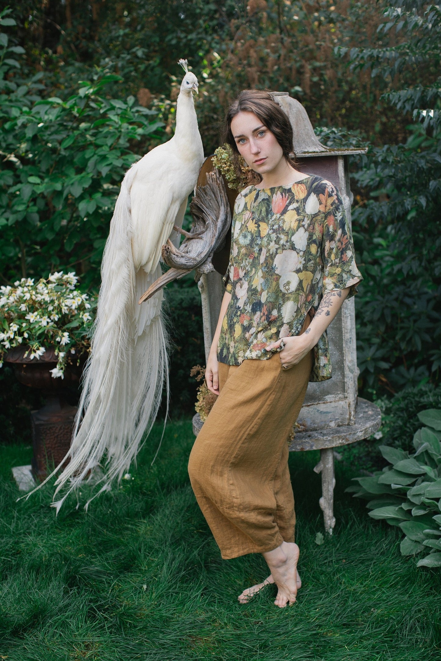 Model wearing the I Dream in Flowers Luxe Tee featuring painterly florals by Jan Brueghel and hidden bumblebee trim – Market of Stars.