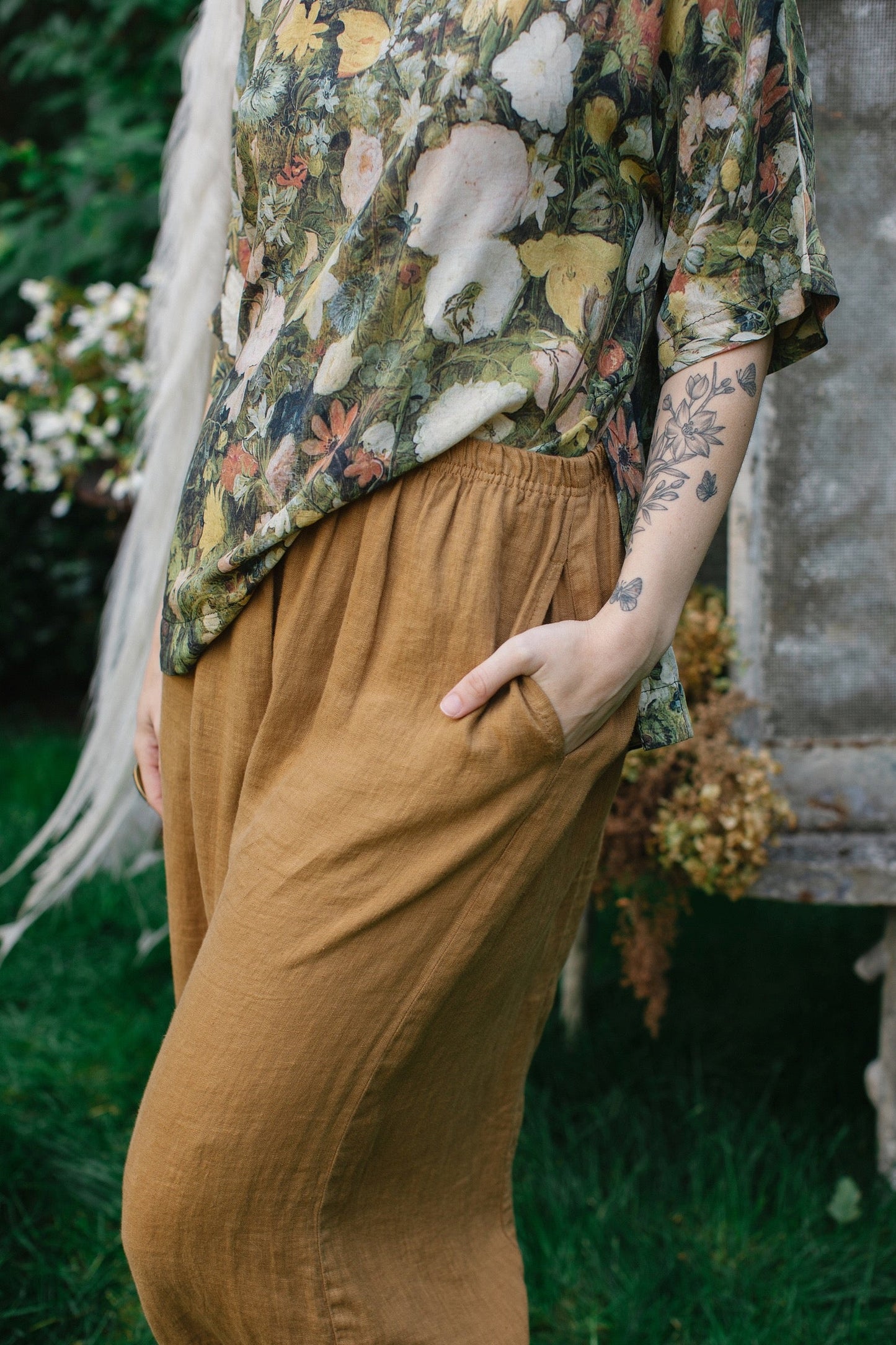 Model wearing the I Dream in Flowers Luxe Tee featuring painterly florals by Jan Brueghel and hidden bumblebee trim – Market of Stars.
