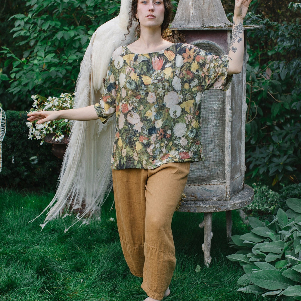 
                  
                    Model wearing the I Dream in Flowers Luxe Tee featuring painterly florals by Jan Brueghel and hidden bumblebee trim – Market of Stars.
                  
                