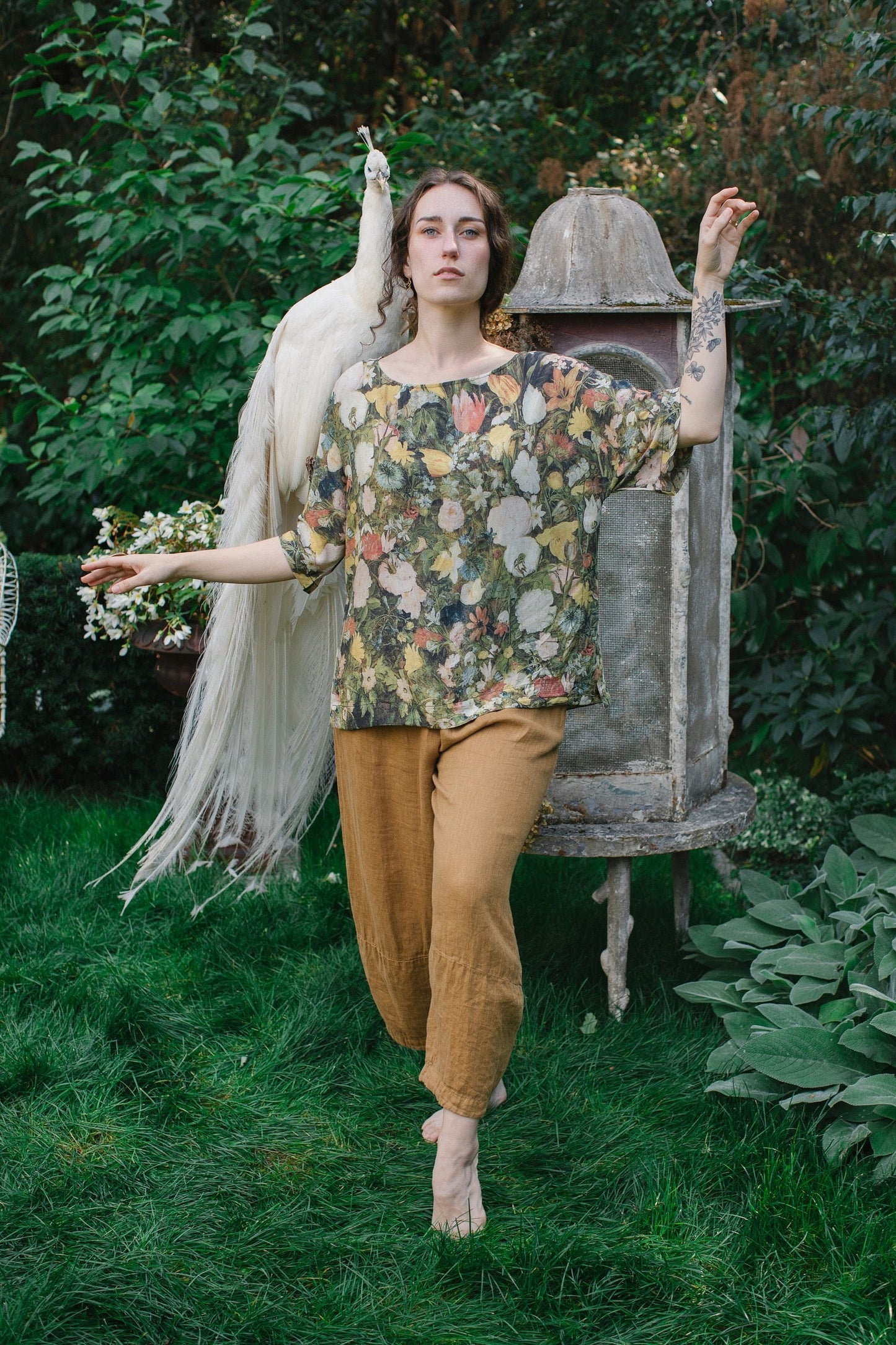 Model wearing the I Dream in Flowers Luxe Tee featuring painterly florals by Jan Brueghel and hidden bumblebee trim – Market of Stars.