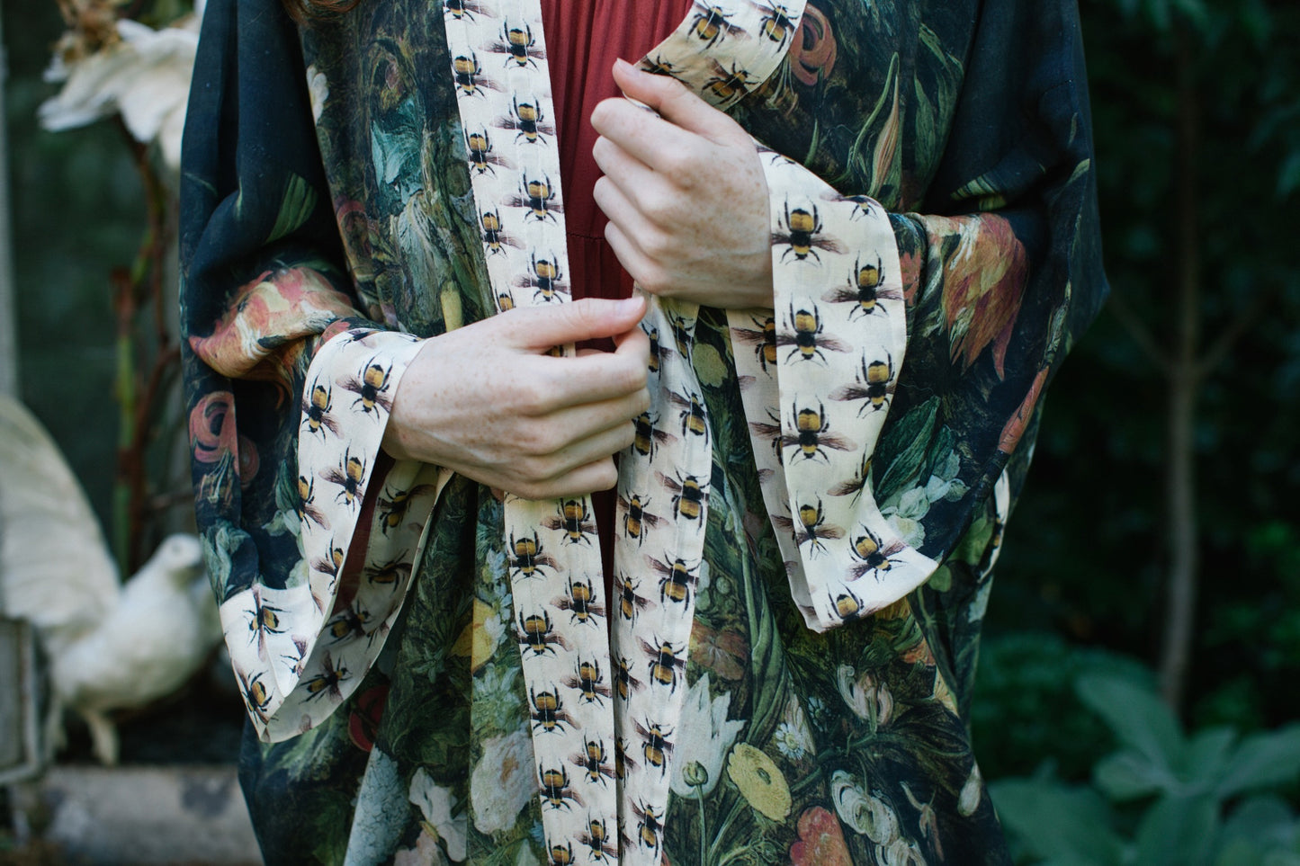 Model wearing the I Dream in Flowers Opera Duster featuring floral oil painting by Jan Brueghel and Victorian bumblebee trim – Market of Stars.