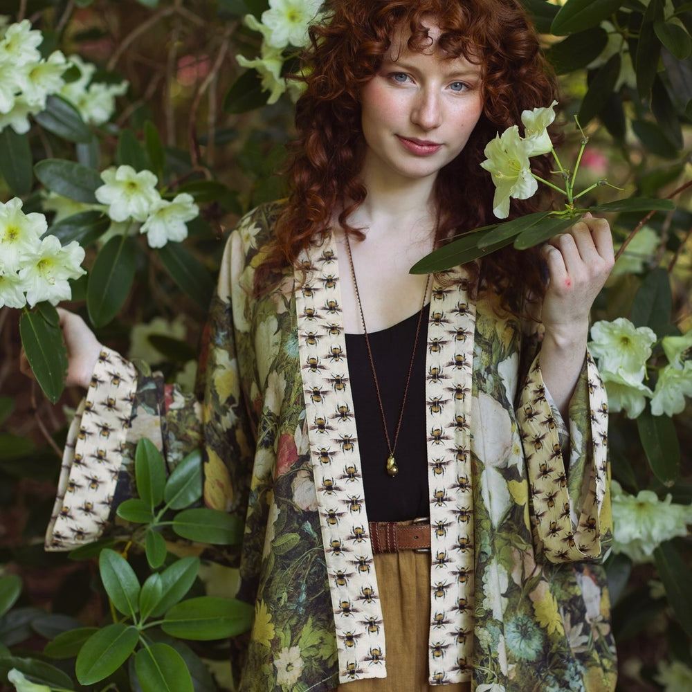 
                  
                    Model wearing the I Dream in Flowers cropped kimono featuring romantic floral artwork by Jan Brueghel and Victorian bumblebee trim – Market of Stars.
                  
                