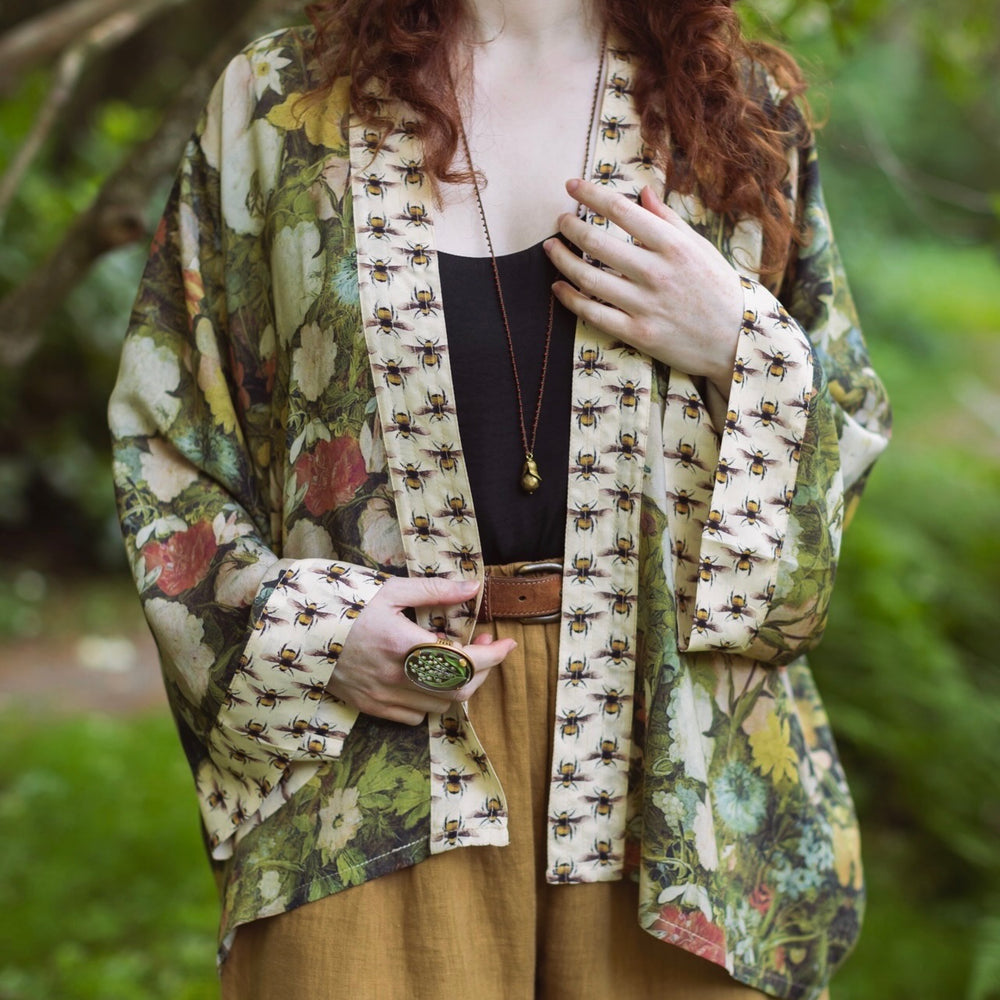 
                  
                    Model wearing the I Dream in Flowers cropped kimono featuring romantic floral artwork by Jan Brueghel and Victorian bumblebee trim – Market of Stars.
                  
                
