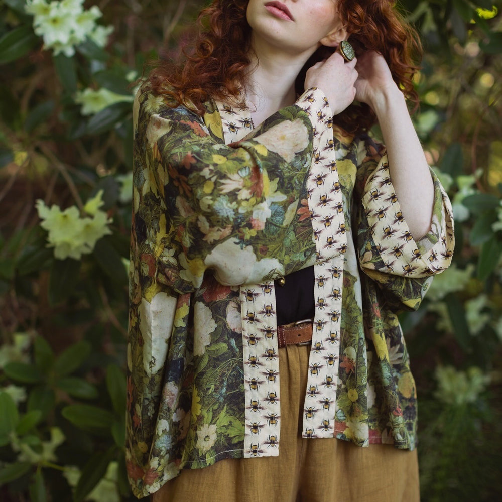 
                  
                    Model wearing the I Dream in Flowers cropped kimono featuring romantic floral artwork by Jan Brueghel and Victorian bumblebee trim – Market of Stars.
                  
                