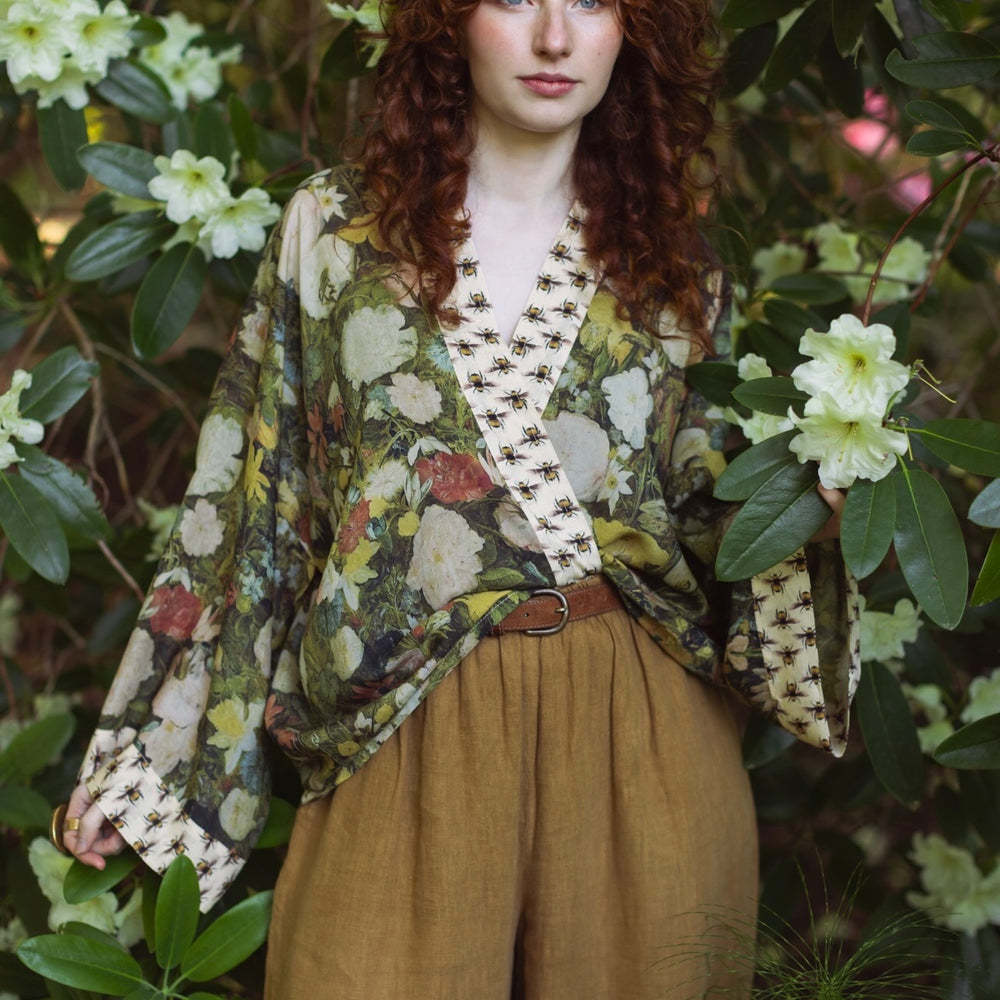 
                  
                    Model wearing the I Dream in Flowers cropped kimono featuring romantic floral artwork by Jan Brueghel and Victorian bumblebee trim – Market of Stars.
                  
                