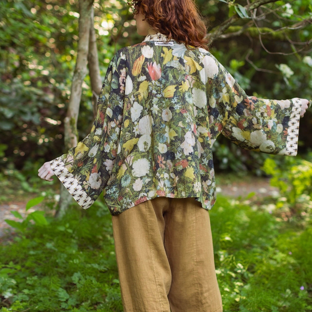 
                  
                    Model wearing the I Dream in Flowers cropped kimono featuring romantic floral artwork by Jan Brueghel and Victorian bumblebee trim – Market of Stars.
                  
                