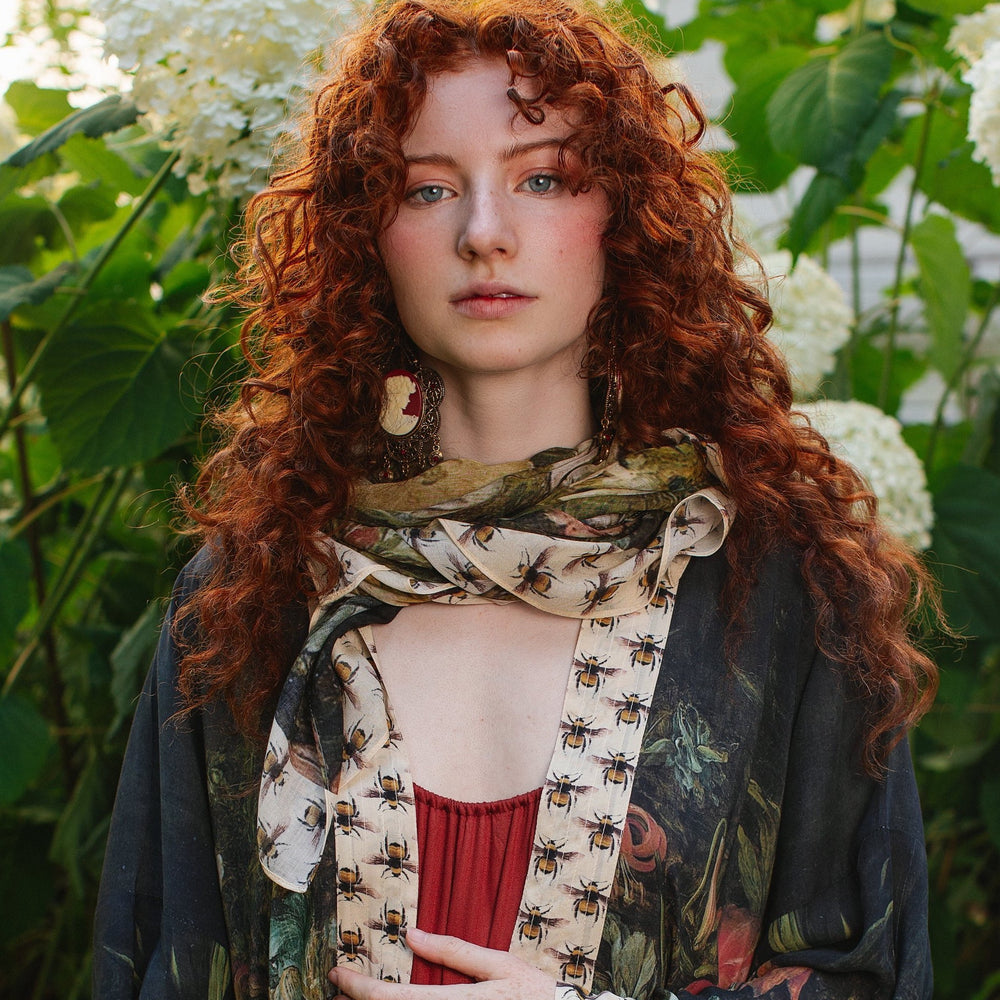 Model wearing the I Dream in Flowers Scarf featuring lush floral art by Jan Brueghel and charming Victorian bumblebees – Market of Stars.
